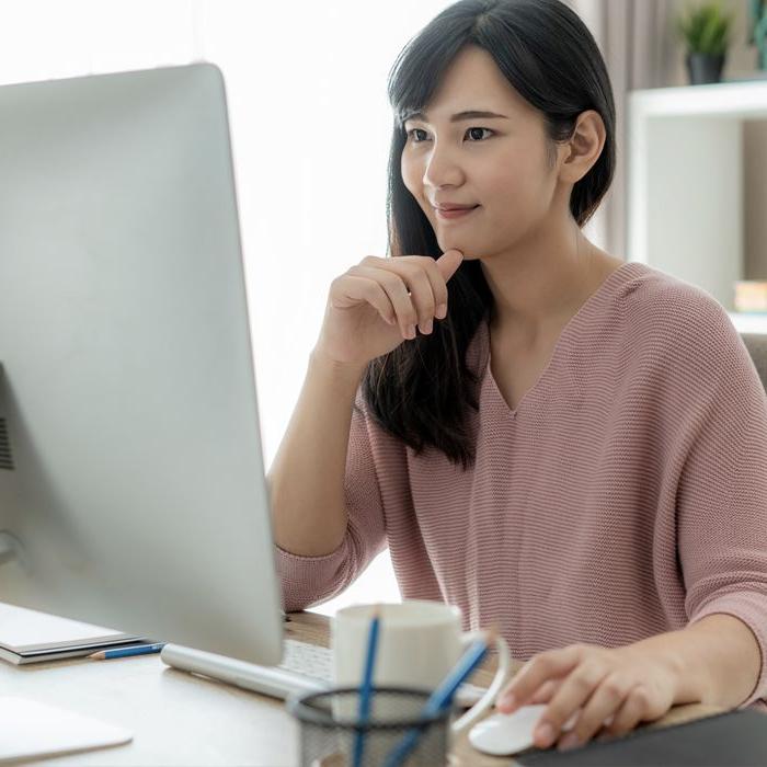 A woman sets up an international wire transfer from her desktop computer.